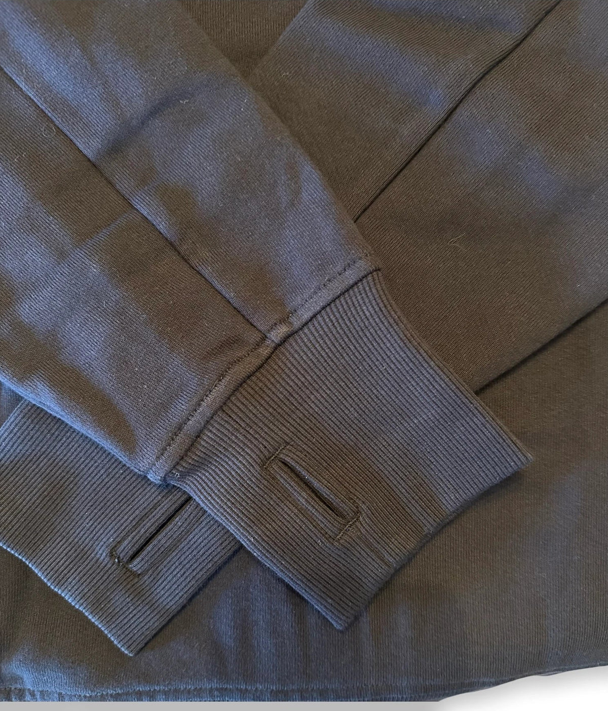 The end of the sleeves folded of a black sweater