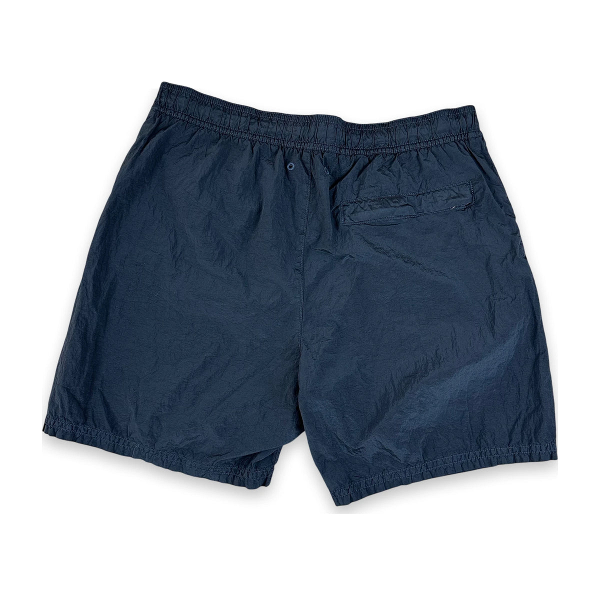 A pair of dark navy blue swim shorts with an elastic waistband and a side pocket, laid flat on a white background.