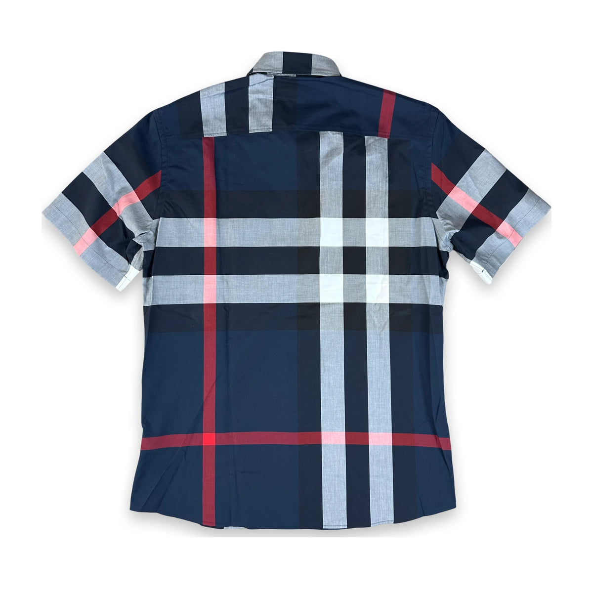 A short-sleeve plaid button-up shirt shown flat against a white background. The shirt features a navy blue base with a grid pattern of light gray, black, and red stripes.