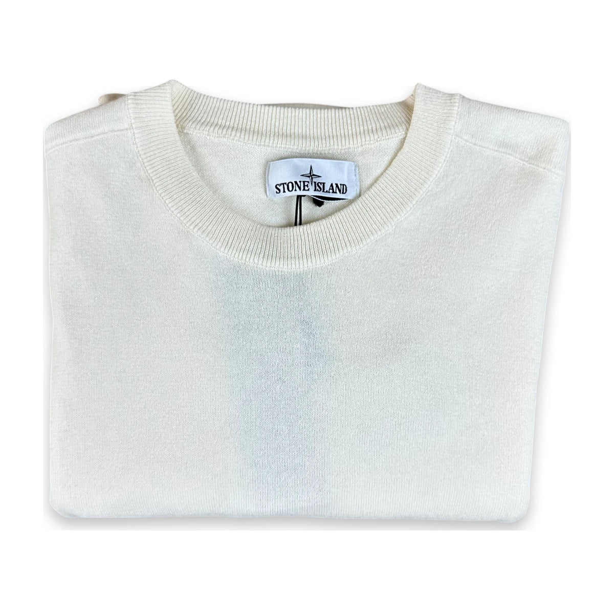 A folded Stone Island crewneck sweater in off-white/cream, showing the brand label inside the collar on a white background.