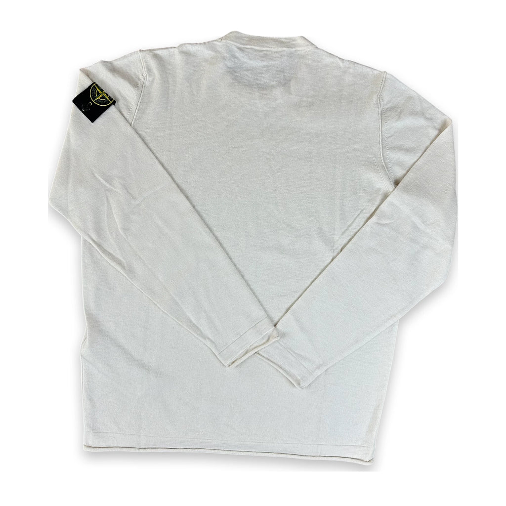 A white Stone Island long-sleeve shirt shown from the back, featuring the brand's signature compass patch on the left shoulder, laid flat on a white background.