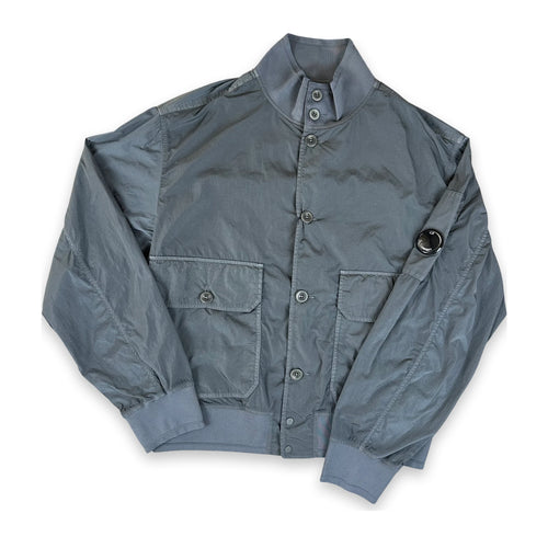 A gray nylon bomber jacket with a stand-up collar, button-up front, and flap pockets, laid flat on a white background.