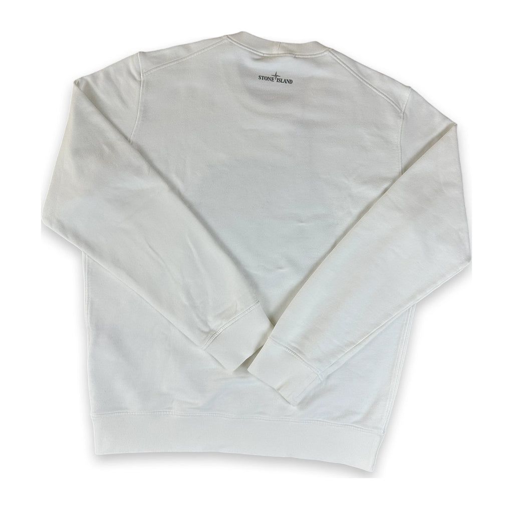A white long-sleeve crewneck sweatshirt laid flat on a white background, showing the back side with a small black 'STONE ISLAND' brand label printed inside the collar.