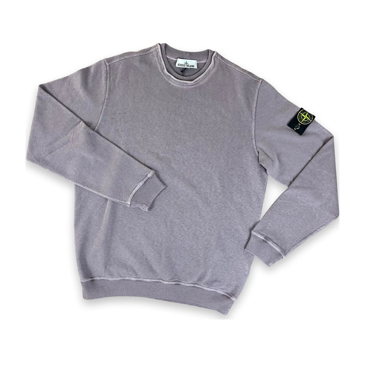 A heather gray crewneck sweatshirt by Stone Island, featuring the brand's signature compass patch on the left sleeve, displayed flat against a white background.