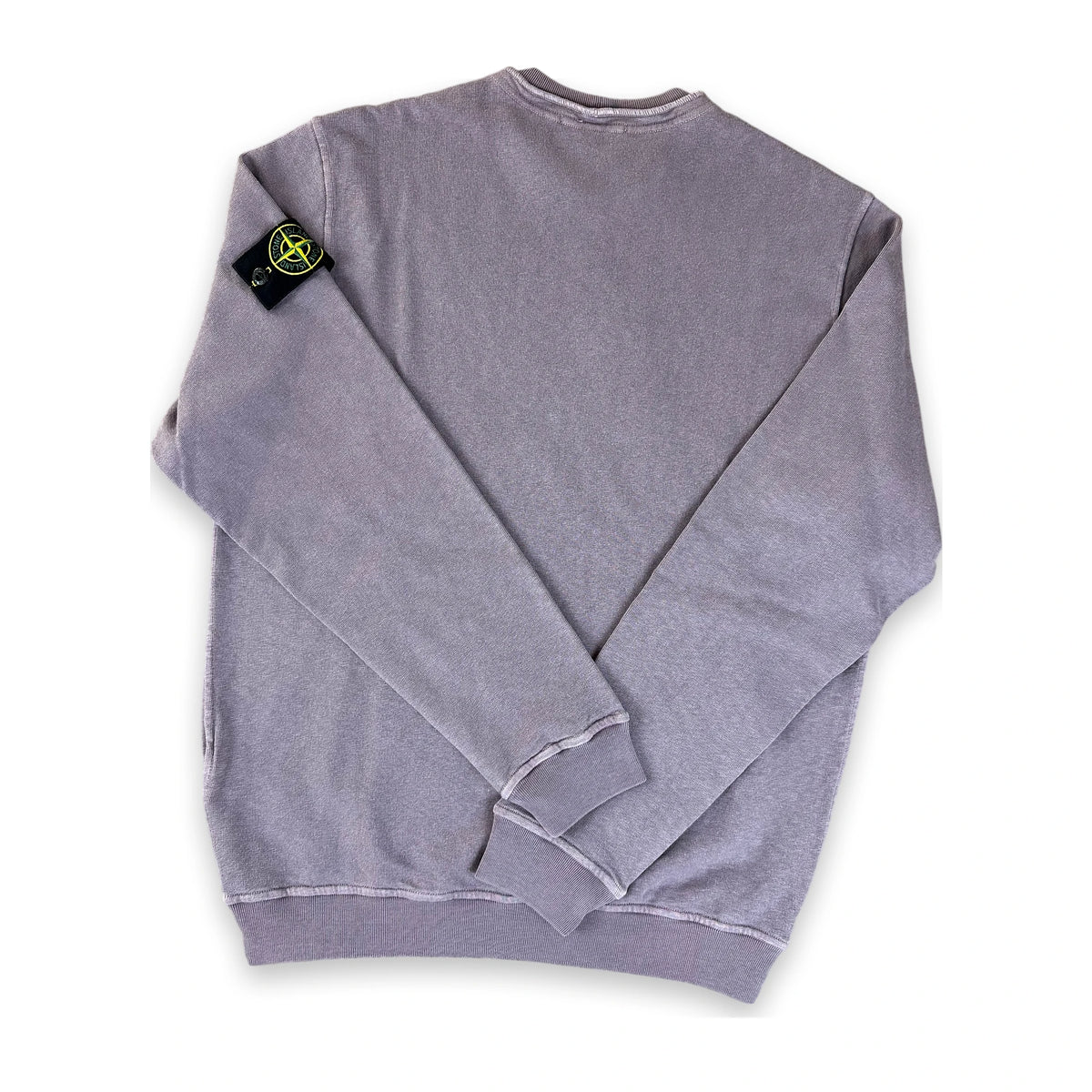 A folded heather gray crewneck sweatshirt with the Stone Island compass logo patch on the left sleeve, displayed on a clean white background.