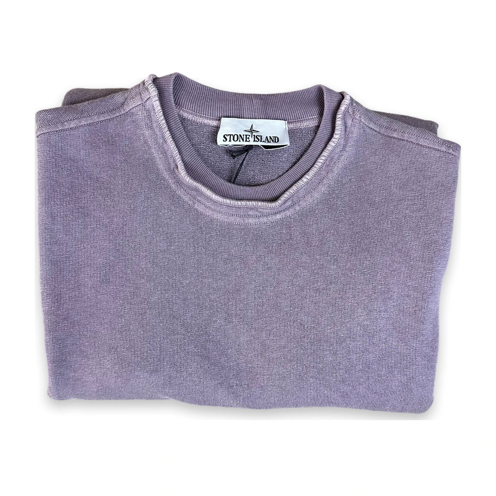 A folded Stone Island crewneck sweatshirt in a dusty lavender-purple color, displayed on a clean white background.