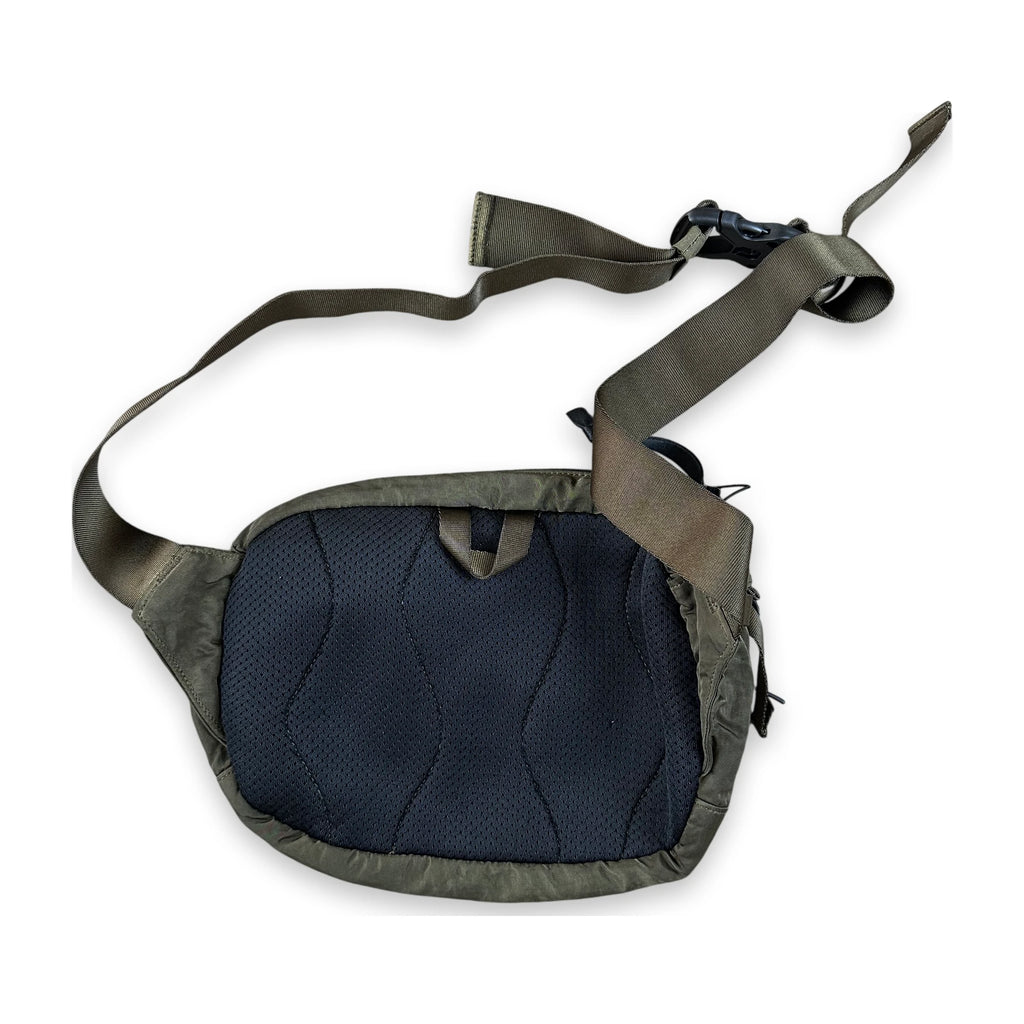 A tactical waist bag in olive green and dark navy blue, featuring a padded mesh front panel and an adjustable webbing strap with a quick-release buckle, shown on a plain white background.