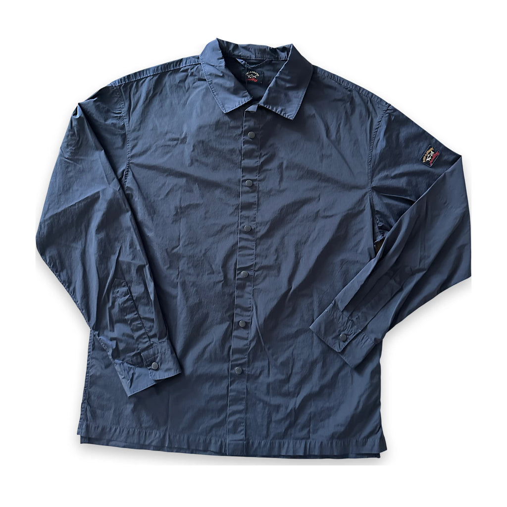 A dark navy blue long-sleeve button-up shirt laid flat on a white background, featuring a classic collar, button front, and a small embroidered logo on the left sleeve.