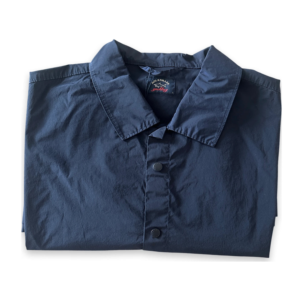 A folded navy blue long-sleeve button-up shirt with a pointed collar, laid flat on a white background.