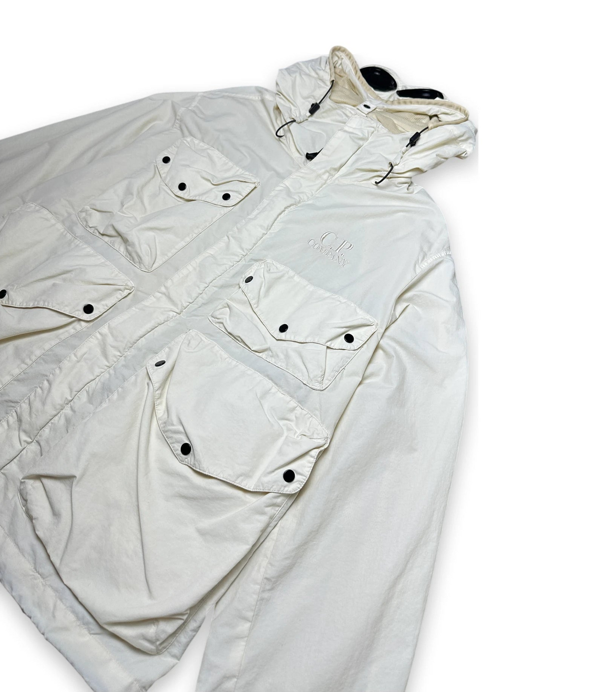 An off-white hooded utility jacket with multiple flap pockets and snap buttons, laid flat on a white background.