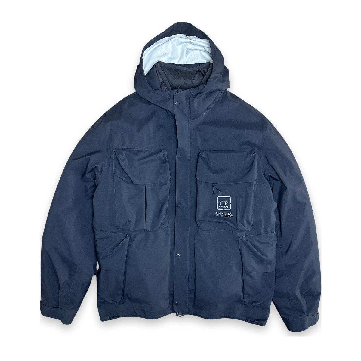 A navy blue hooded utility jacket with multiple front pockets and a small white embroidered logo patch on the left chest, displayed against a plain white background.