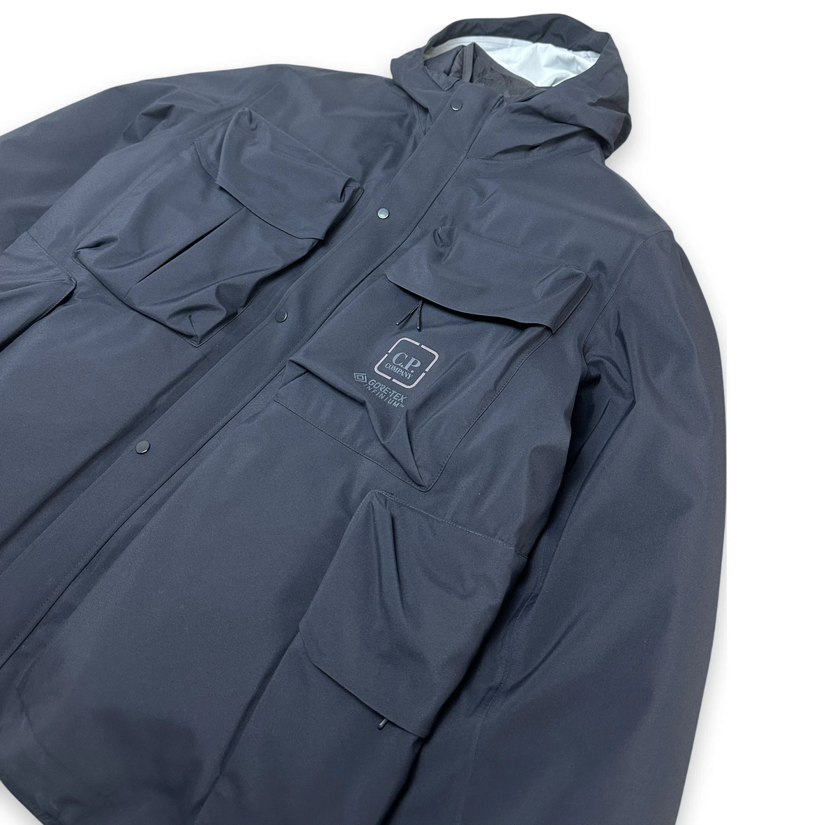 Navy jacket with C.P. Company brand logo on a white background