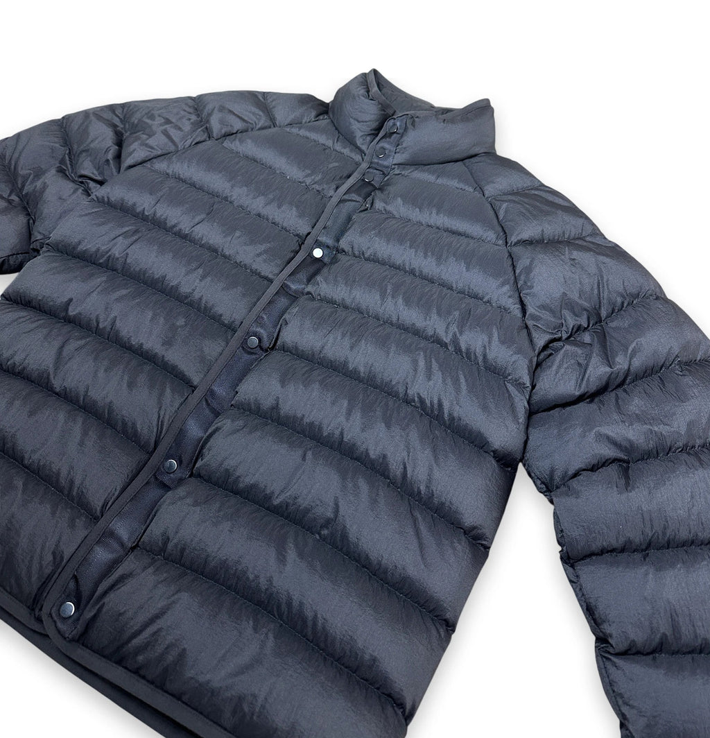 A dark gray quilted puffer jacket with a button-up front and stand collar, shown on a plain white background.