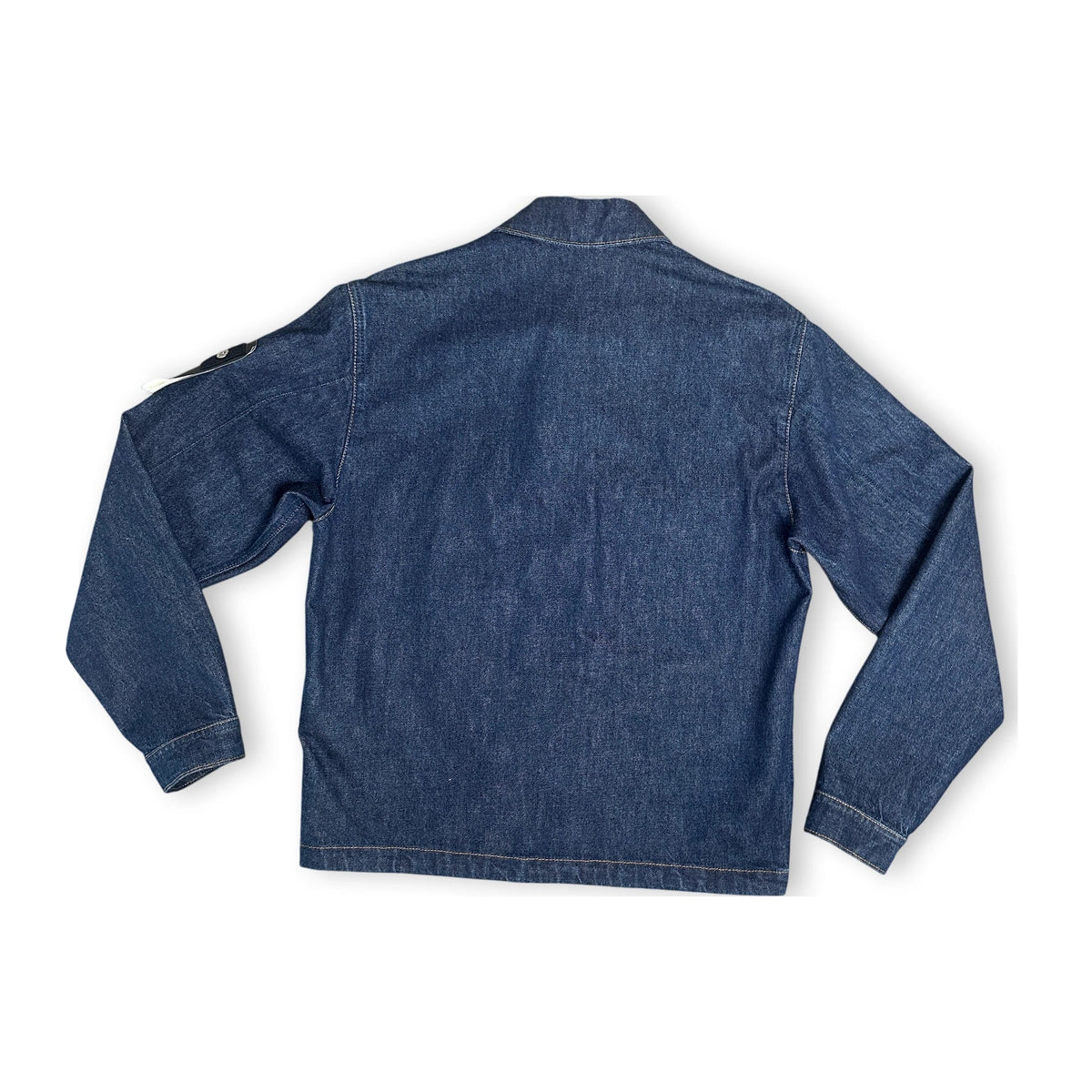 The back of a denim coach jacket on a white background