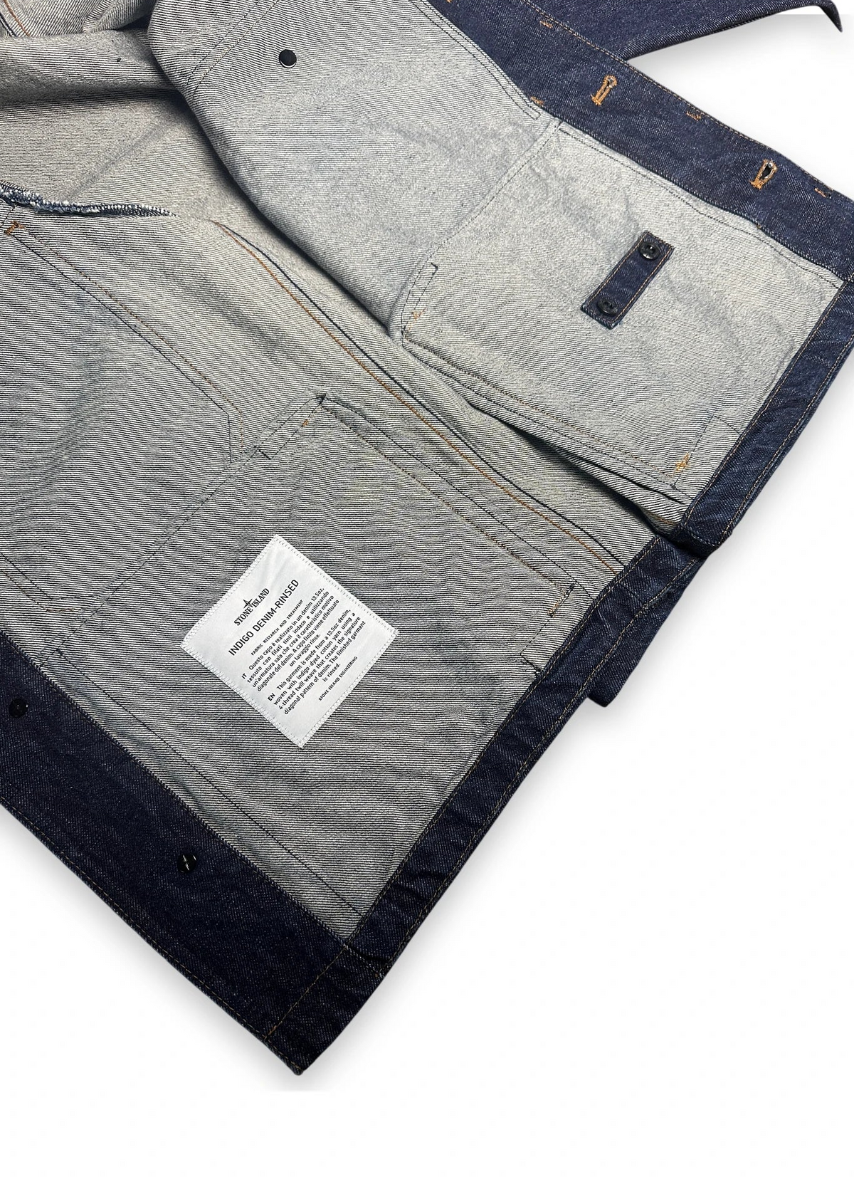 Inside of a denim jacket showing its label on a white background