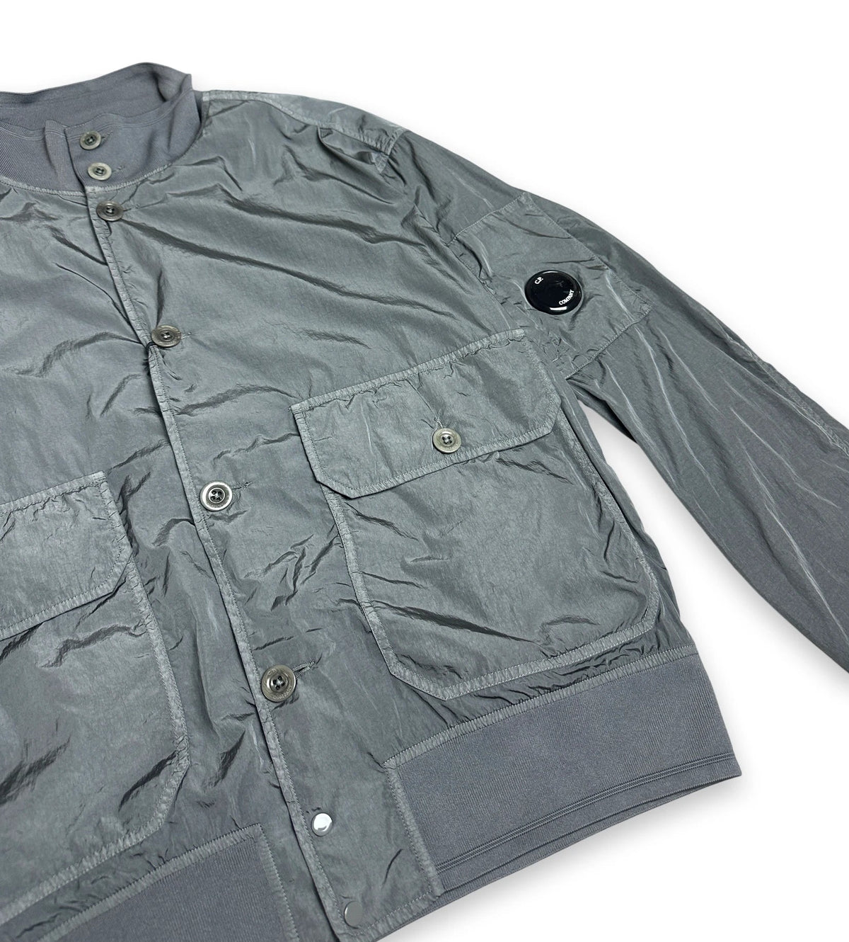 A gray lightweight utility jacket with multiple flap pockets and metal snap buttons, shown on a plain white background.