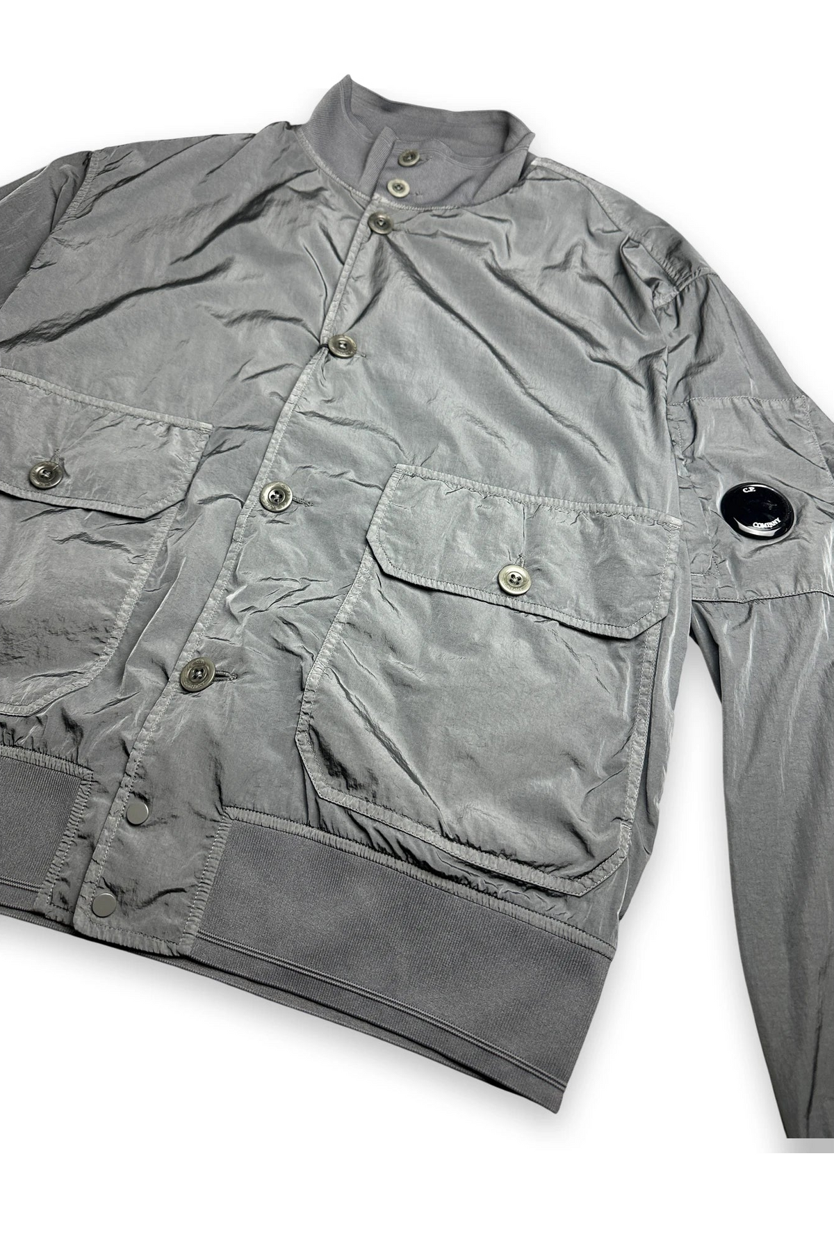 A gray lightweight jacket with a stand collar, button front, and multiple flap pockets, shown on a plain white background.