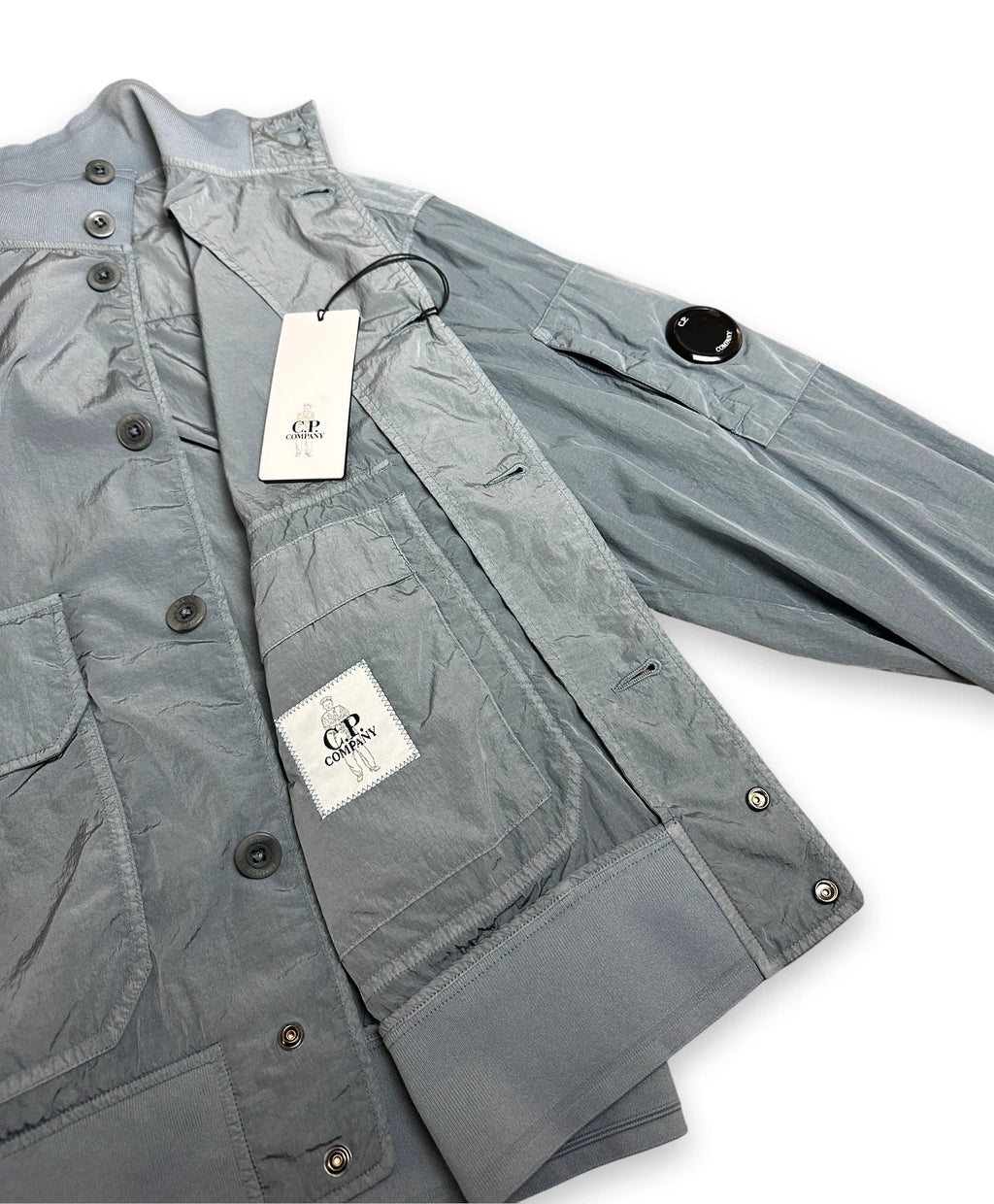 Chrome bomber jacket folded open showing C.P. Company label and swing tags