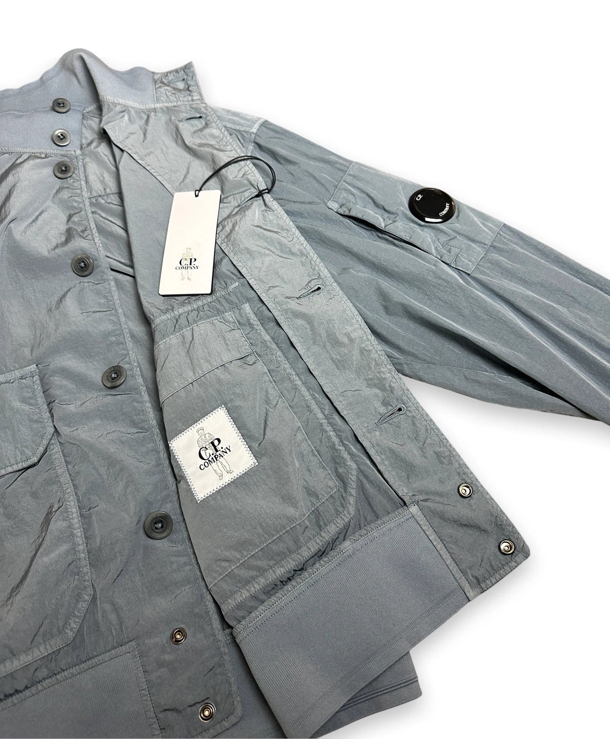 Chrome bomber jacket folded open showing C.P. Company label and swing tags