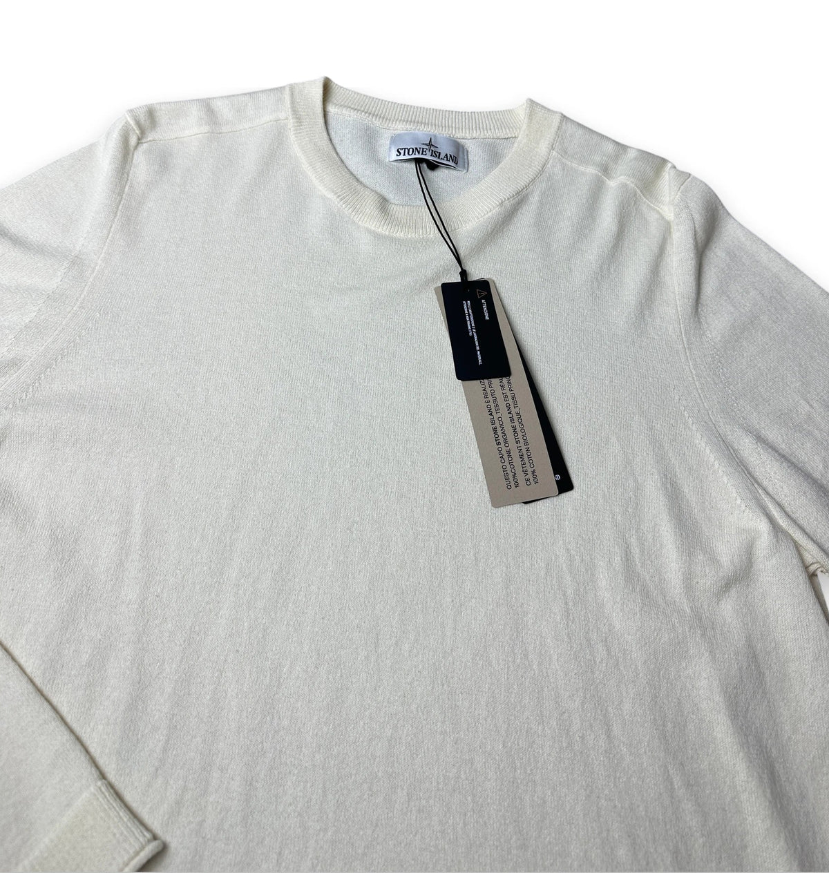 An off-white crewneck knit sweater with a hangtag, shown flat against a white background.