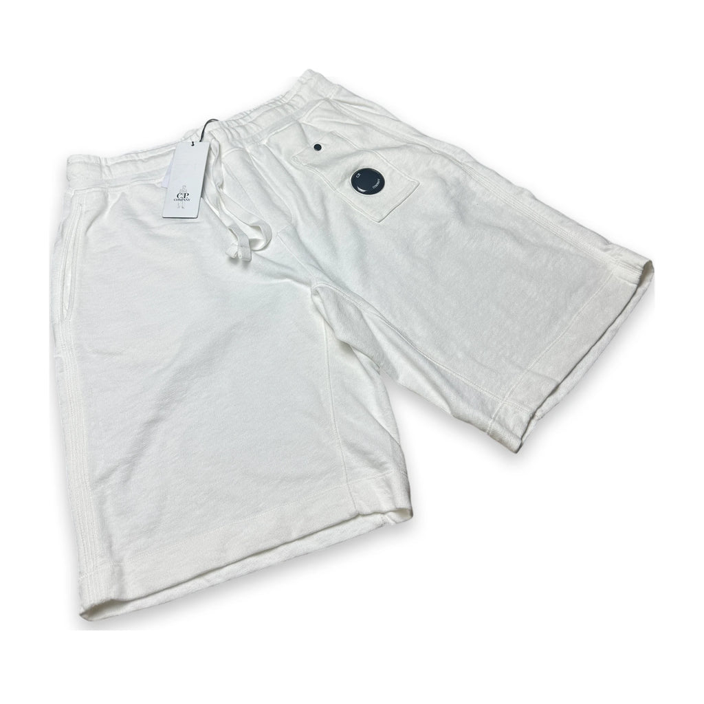 White relaxed sweatpants with a lens of the brand C.P. Company and a swingtag on a white background