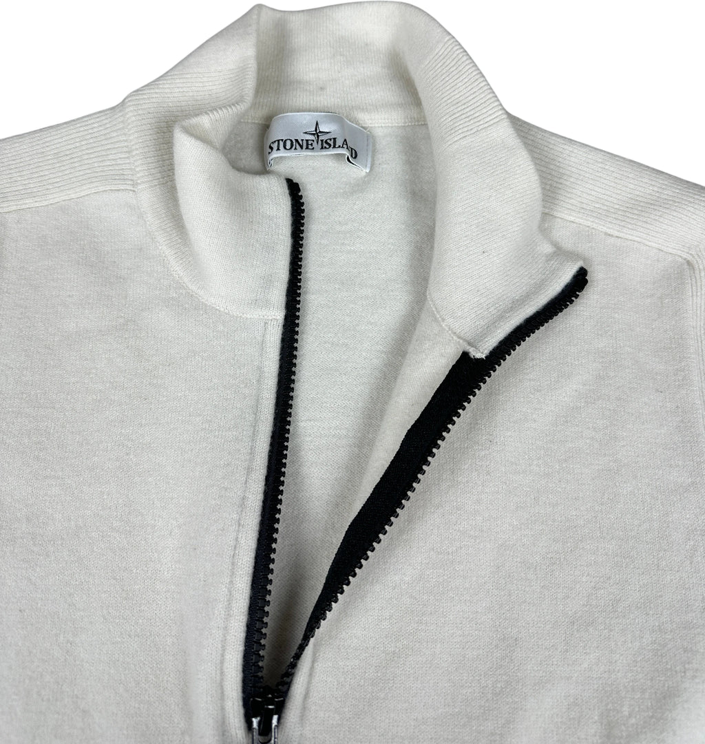 Close-up of a Stone Island quarter-zip pullover in off-white fleece, showing the black zipper and the Stone Island brand label inside the collar.